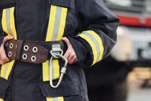 Female firefighter in protective uniform standing near truck.