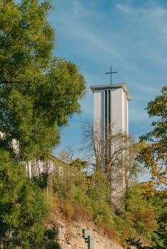 Modern Church Tower with Big Metal Cross. Modern church tower crowned with iron crosses on sunset sky background.