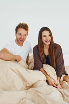 Happy couple together. Interior and design of beautiful modern bedroom at daytime.