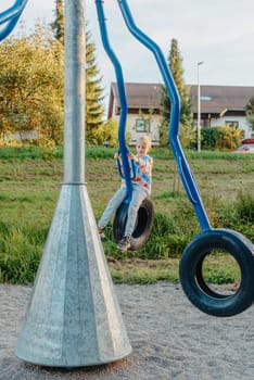 Funny cute happy baby playing on the playground. The emotion of happiness, fun, joy. Smile of a child. boy playing on the playground.