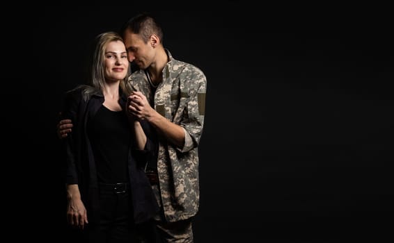 Happy woman hugging his husband came back from army. Smiling cheerful caucasian girlfriend embracing a soldier
