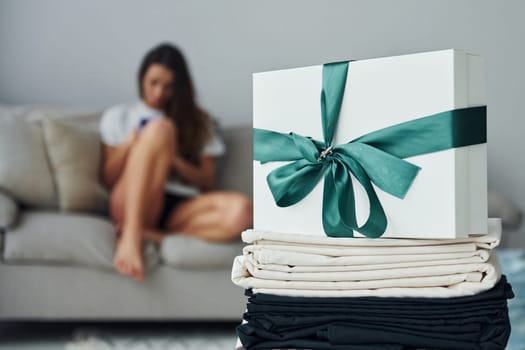 Cheerful girl is on the bed. Interior and design of beautiful modern bedroom at daytime.