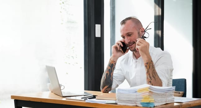 Happy business man with phone call while relaxing in the office.