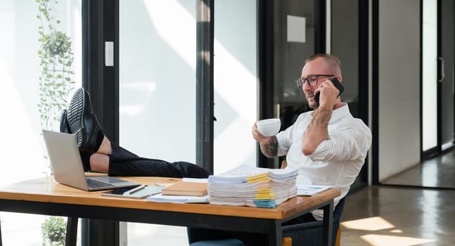 Happy business man with phone call while relaxing in the office.