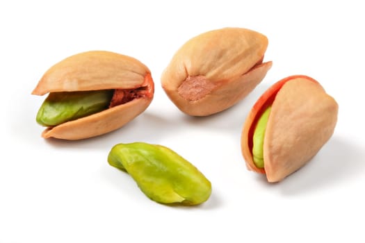 Turkish red roasted pistachios in shell, some of green nuts visible, isolated on white background.