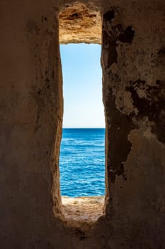 A window to the sea. View of the sea and horizon in the guardhouse of an old fortress from the 17th century in the city of Salvador, Bahia.