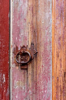 Detail of antique colorful wooden door and lock deteriorated by time and rust in a colonial style house in the historic city of Diamantina in Minas Gerais