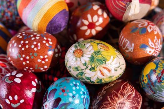 Close-up view from above. Randomly stacked close together, the Easter eggs form a colorful Easter composition while tightly filling the entire frame.