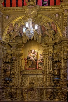 Interior of a baroque church decorated with images of saints and walls with gold leaf ornaments in the historic city of Ouro Preto, Minas Gerais