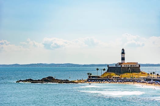 Barra beach and lighthouse seen from afar with the summer sun of Salvador in Bahia