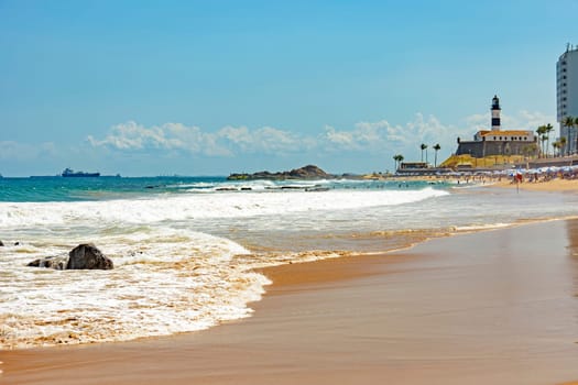 Barra beach buildings and lighthouse seen from afar with the summer sun of Salvador in Bahia