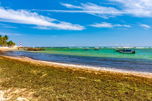Itapua beach and lighthouse, one of the most beautiful and well-known landscapes in the city of Salvador in Bahia with its anchored fishing boats