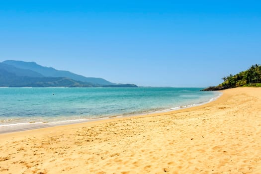 Beach on the island of Ilhabela on the north coast of the state of Sao Paulo with the Sao Sebastiao hills in the background on a sunny day