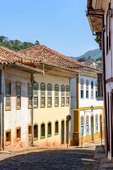 Beautiful street with old colorful houses in colonial architecture, cobblestones and lanterns for lighting