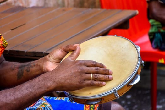 Brazilian samba performance with musician playing tambourine in the streets of Pelourinho, city of Salvador, Bahia