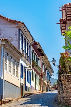Cobblestone street with old and colorful colonial houses in the historic city of Ouro Preto in the state of Minas Gerais, Brazil