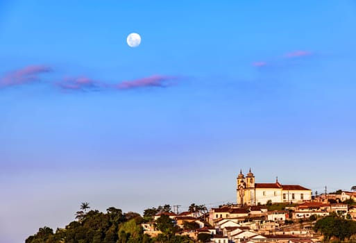 Colonial style church on the mountain with moonlight in the background in the historic city of Ouro Preto in Minas Gerais, Brazil