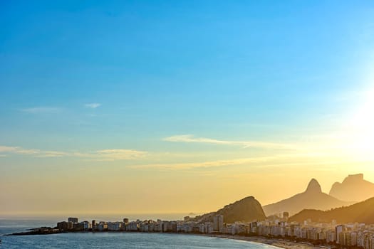 Copacabana Beach, its buildings and the mountains of Rio de Janeiro seen from above during the summer sunset