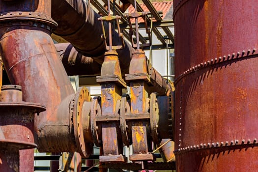 Corroded and rusty gears and pipes of old machinery for processing iron ore abandoned in Minas Gerais, Brazil