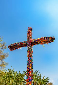 Crucifix decorated with flowers with blue sky in the background common in traditional religious festivals in the interior of Brazil in the state of Minas Gerais