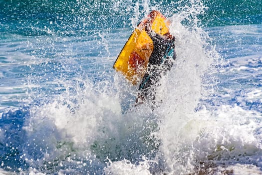 Flight of bodyboarder boy when crashing wave on the beach in Ipanema, Rio de Janeiro