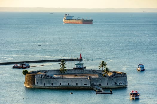 Old fortress of Sao Marcelo during sunset surrounded by the waters of the sea of Salvador and built in the 17th century