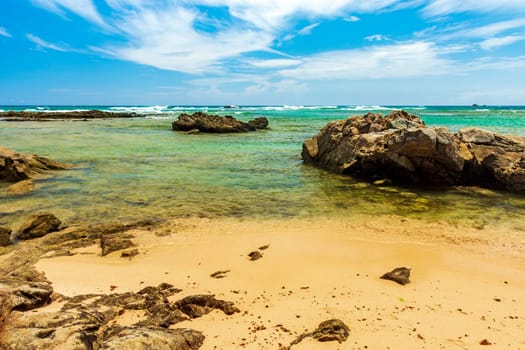 Itapua beach in Salvador, Bahia with the rocks over the sand and entering the sea