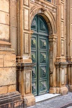 Large green wooden door and stone facade at the entrance to the old historic church in Pelourinho in Salvador