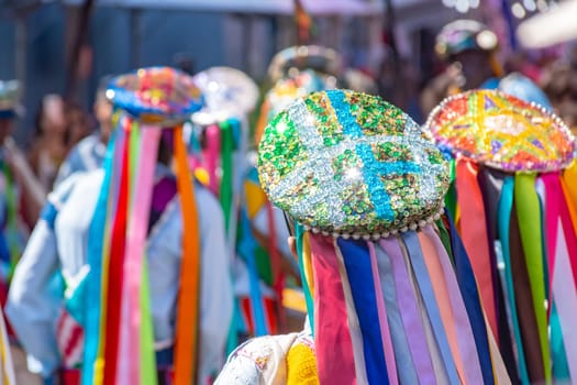 Men dressed in colorful clothes and hats attending a popular religious festival in Minas Gerais, Brazil