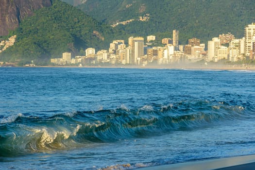 Morning at Ipanema beach in Rio de Janeiro with its buildings, sea and city life