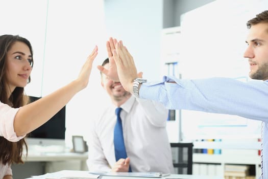 Successful business ladies in office at their desk give each other five hands. Development of business project and successful financial start of concept