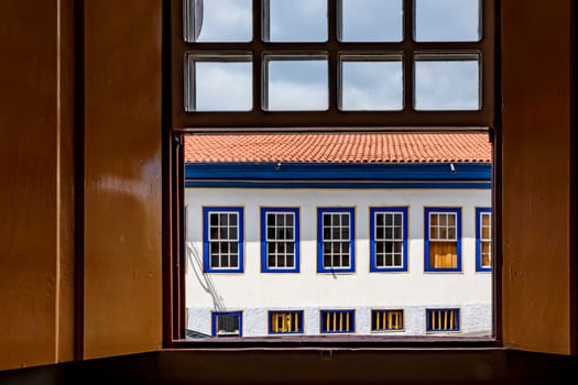 Old colonial style houses seen through a wooden window in the historic town of Diamantina in Minas Gerais, Brazil