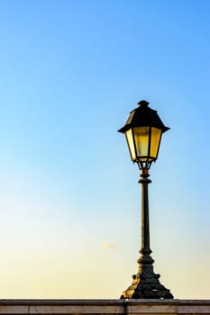 Old colonial style lamppost on the walls of the streets of Salvador, Bahia during summer sunset.