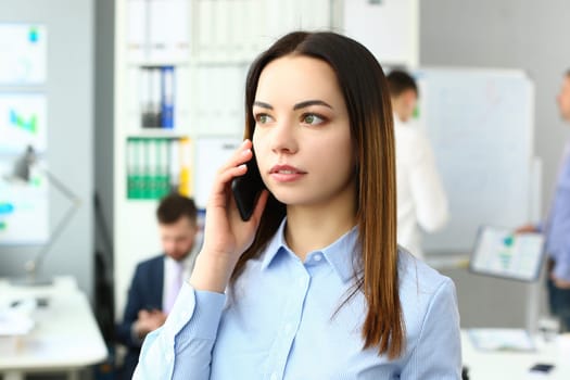 Portrait of beautiful businesswoman with phone in office. Business consultant and stay connected concept