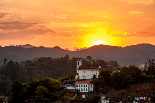 Old historic colonial church among the mountains of Ouro Preto city during sunset
