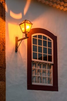 Old metal street lamp on the facade of a colonial-style house in the historic city of Tiradentes, Minas Gerais