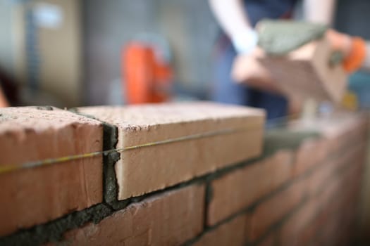 Master builder makes brickwork in house. Construction of brick interior partitions concept