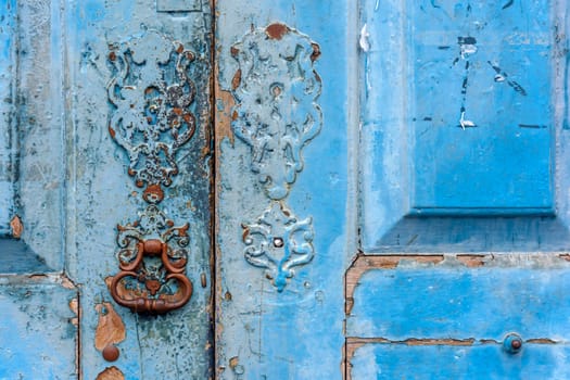 Detail of old wooden blue door and lock deteriorated by time and rust in a colonial style house in the historic city of Diamantina in Minas Gerais