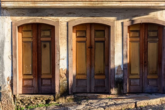 Old wooden doors spoiled by time on the facade of a colonial style house in the city of Ouro Preto, Minas Gerais