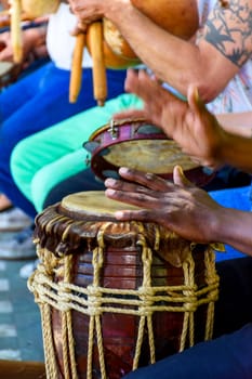 Percussionist playing a rustic and rudimentary percursion instrument atabaque during afro-brazilian cultural manifestation