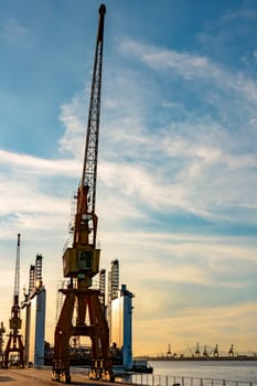 Several cranes and the view of the pier in the port of Rio de Janeiro during sunset.