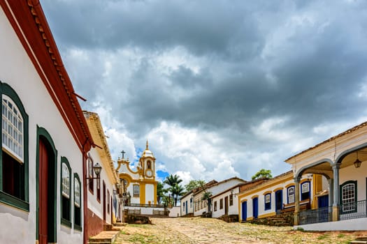 Street and old colonial style houses in the historic city of Tiradentes in Minas Gerais with a baroque church in the background