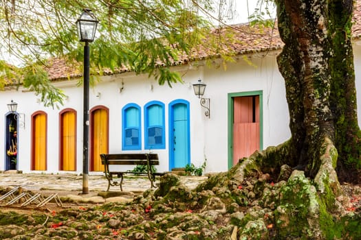 Streets of cobblestone and old houses in colonial style behind the tree on the streets of the old and historic city of Paraty founded in the 17th century on the coast of the state of Rio de Janeiro, Brazil