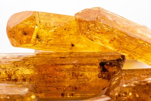 Studio photography of Brazilian imperial topaz in raw state with white background