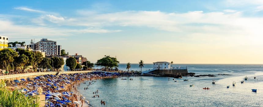 Sunny Sunday in the summer of the city of Salvador in Bahia with Barra beach full of people during sunset