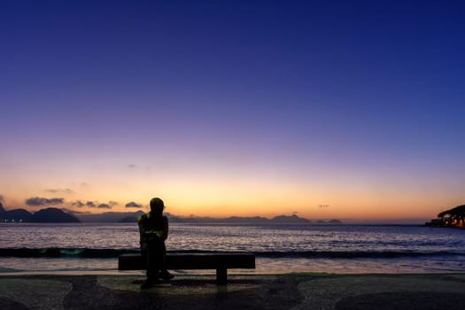 Sunrise on the famous Copacabana beach during the summer of Rio de Janeiro with its colors, horizon and the sea