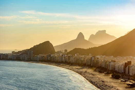 Golden sunset between Copacabana buildings and hills