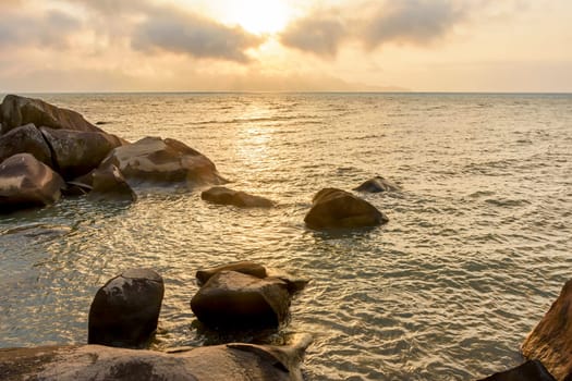 Sunset through the rocks in summer from Ilhabela Island on the Sao Paulo Coast, Brazil