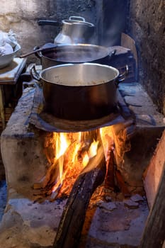 Traditional Brazilian food being prepared on old, dirty and popular wood stove