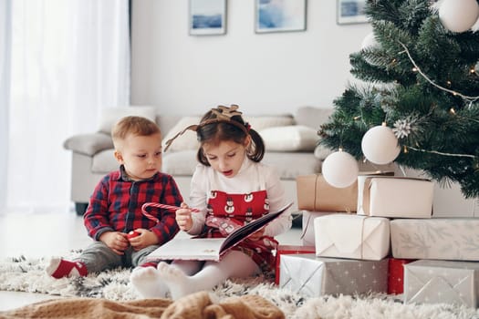 Little brother with her daughter celebrates New year and christmas at home.